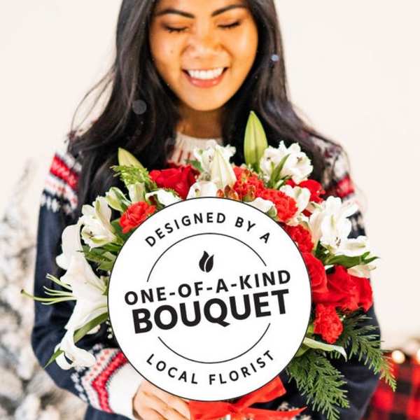 Woman holding a red and white bouquet with lilies and carnations