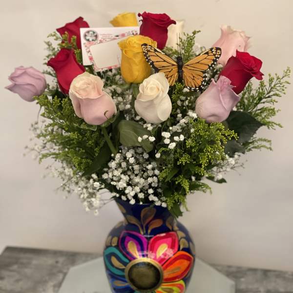 Bouquet of multicolored roses in a painted vase with a butterfly decoration