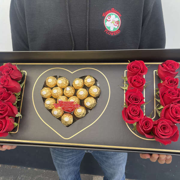 Black gift tray with red roses and Ferrero Rocher chocolates arranged as LOVE