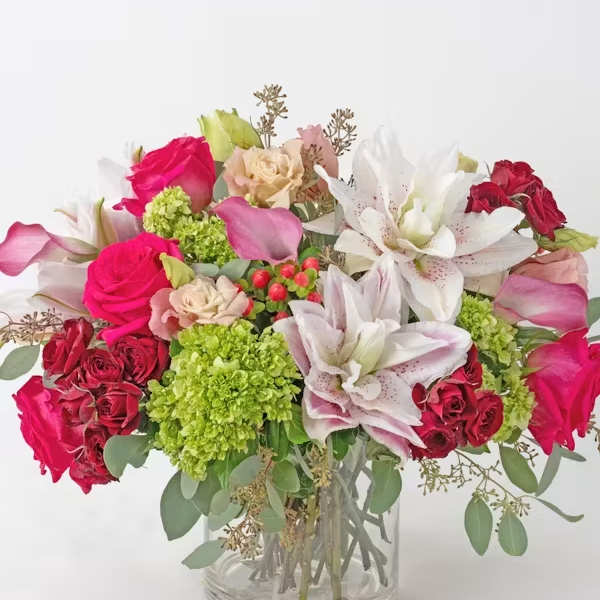 Mixed bouquet of pink and white flowers in a clear glass vase