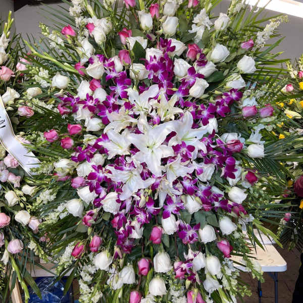 Large standing floral spray with white lilies, pink roses, and purple orchids