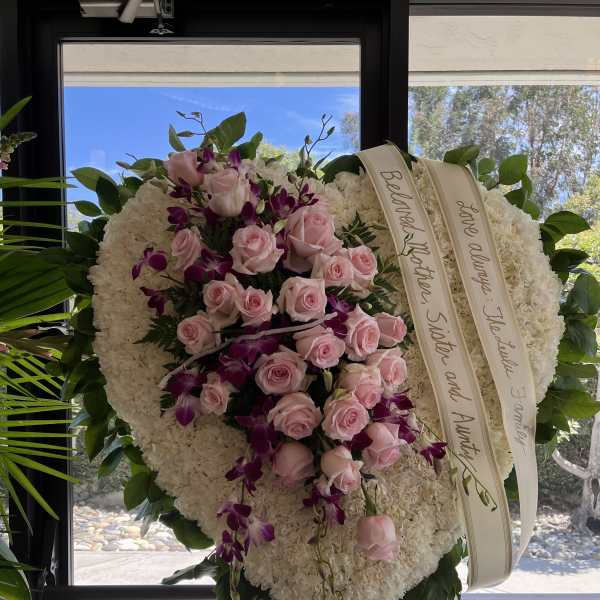 Heart-shaped funeral wreath with pink roses and purple orchids