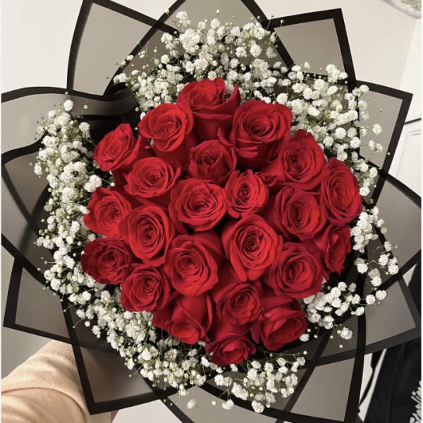 Bouquet of red roses with white baby's breath in black wrap