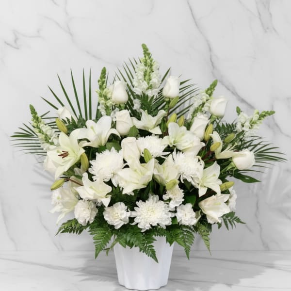 White lilies and chrysanthemums arranged in a white vase