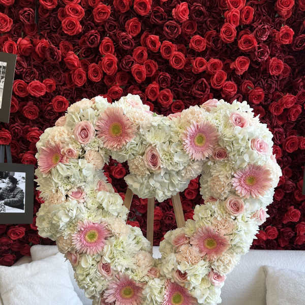 Heart-shaped floral arrangement with pink gerberas, roses, and white hydrangeas