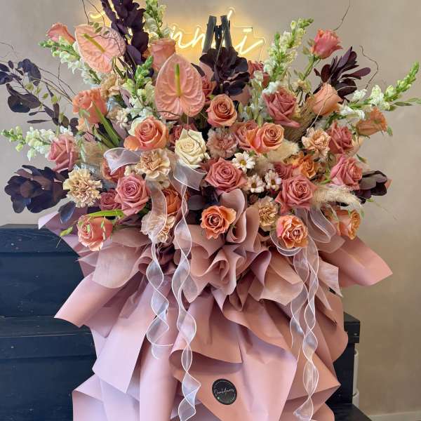 Large bouquet of peach and pink roses with ribbon and wrapping