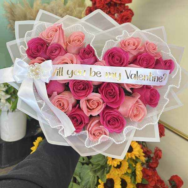 Pink and red rose bouquet with a "Will you be my Valentine?" ribbon