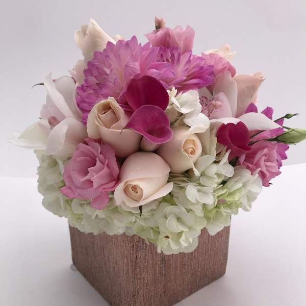 Pink and white floral arrangement in a square vase