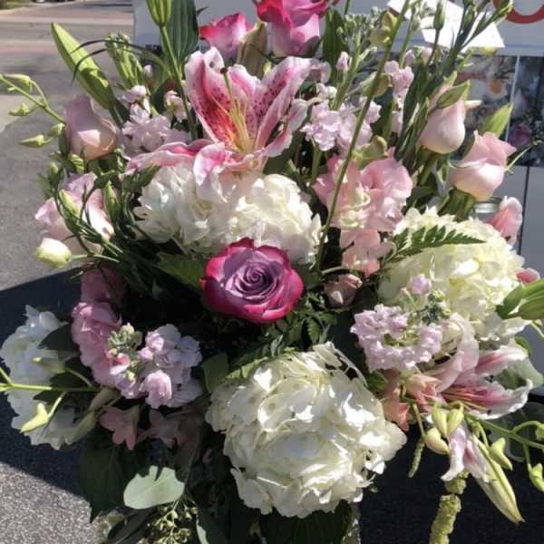 Pink and white mixed bouquet with lilies, roses, and hydrangeas in a clear vase
