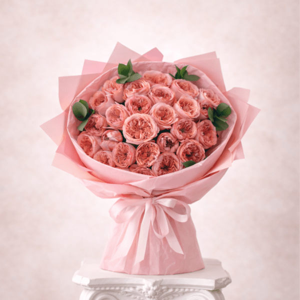 Bouquet of pink roses wrapped in pink paper with a ribbon