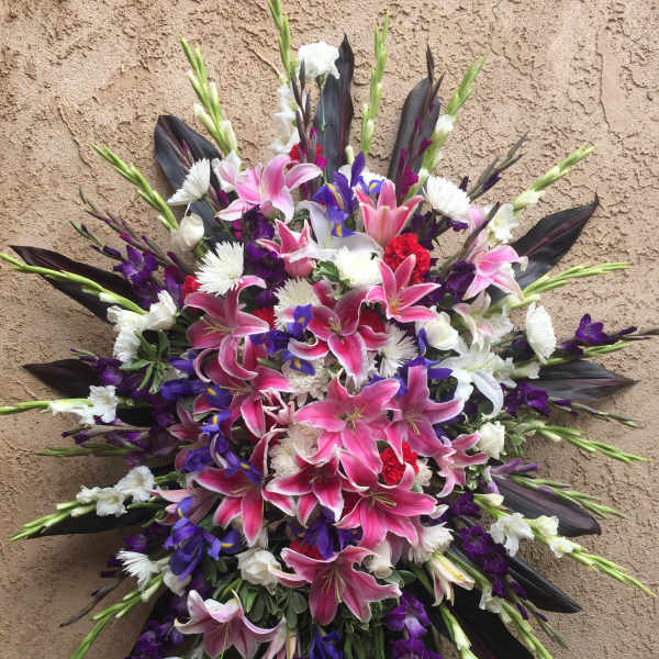 Large bouquet of pink lilies, white flowers, and purple blooms