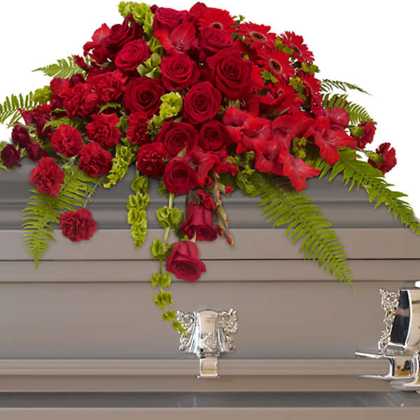 Red rose and carnation casket spray with fern accents