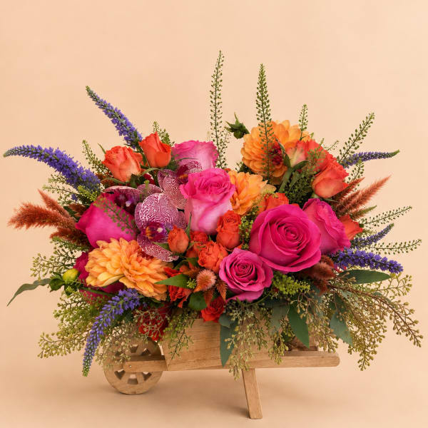 Bright mixed bouquet in a wooden wheelbarrow container