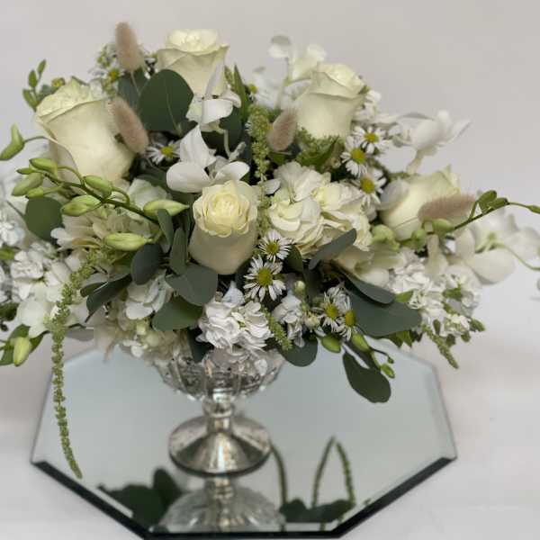 White floral arrangement in a silver pedestal vase