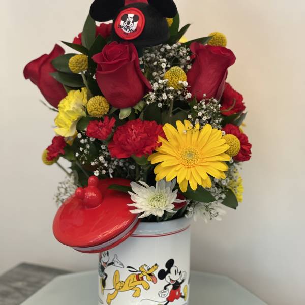 Bouquet of red roses and mixed flowers in a Mickey Mouse tin