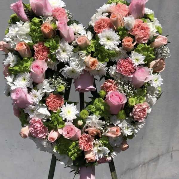 Heart-shaped floral wreath with pink roses and white daisies