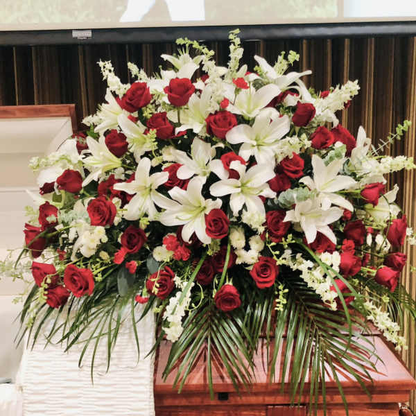 Large funeral spray of red roses and white lilies