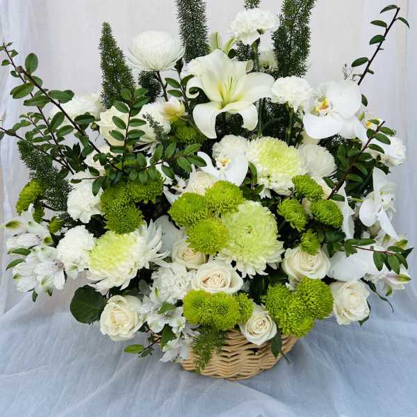 White and green floral basket arrangement with roses, orchids, and chrysanthemums