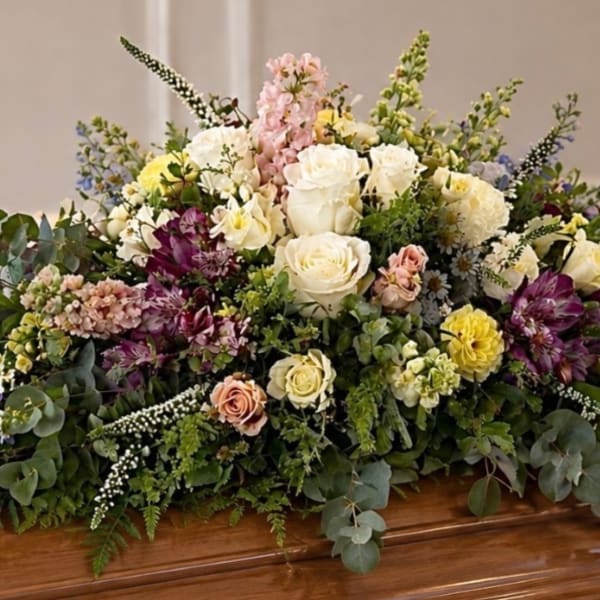 Large casket spray with white, pink, yellow, and purple flowers