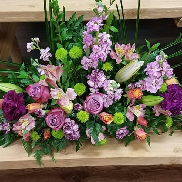 Mixed pink and purple floral arrangement with lilies and roses