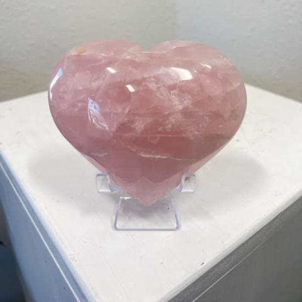 Pink heart-shaped crystal on a clear stand