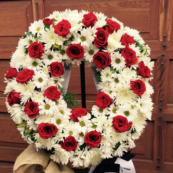 Red roses and white daisies arranged in a circular wreath