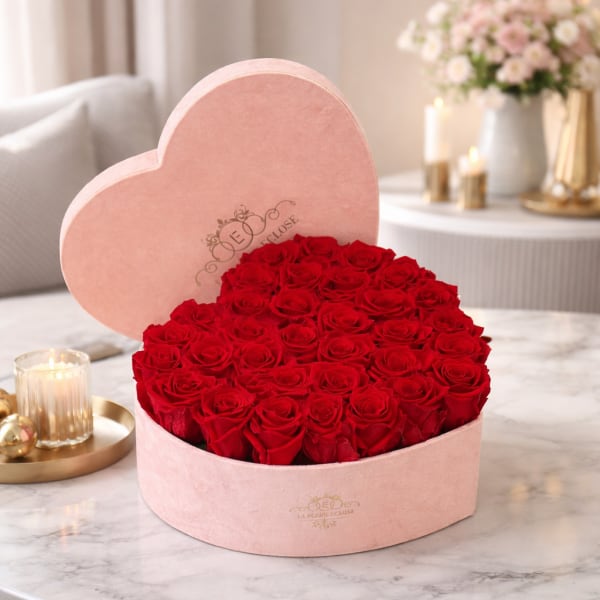 Heart-shaped pink box filled with red roses