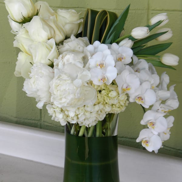White floral arrangement in a tall glass vase