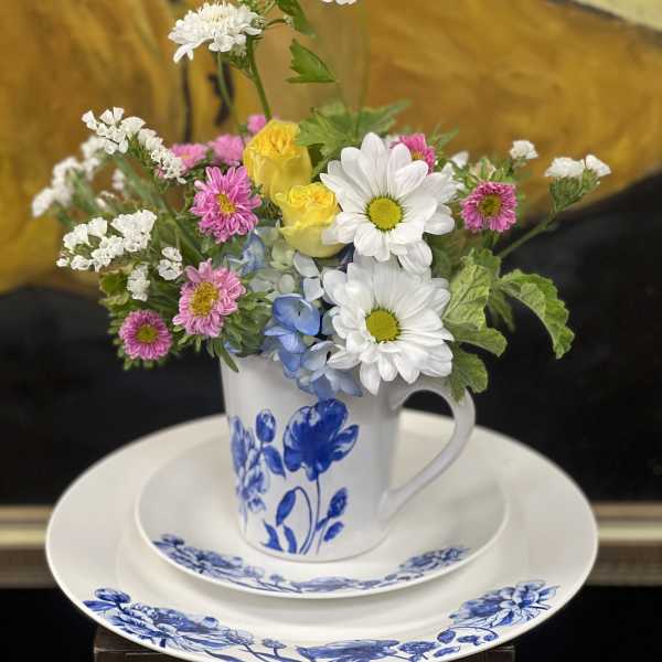 Mixed bouquet in a blue-and-white mug on a matching plate