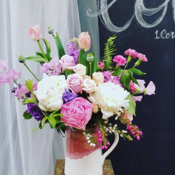 Pink and white mixed bouquet in a white pitcher vase