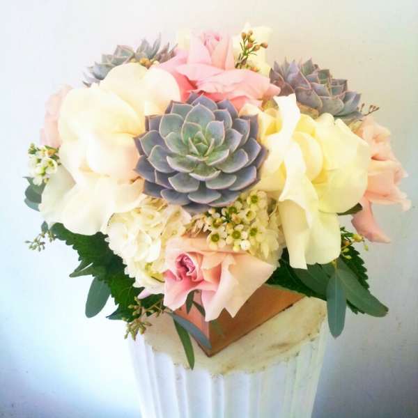 Bouquet of pastel roses and succulents in a vase