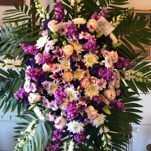 Large standing floral spray with pink, white, and purple flowers