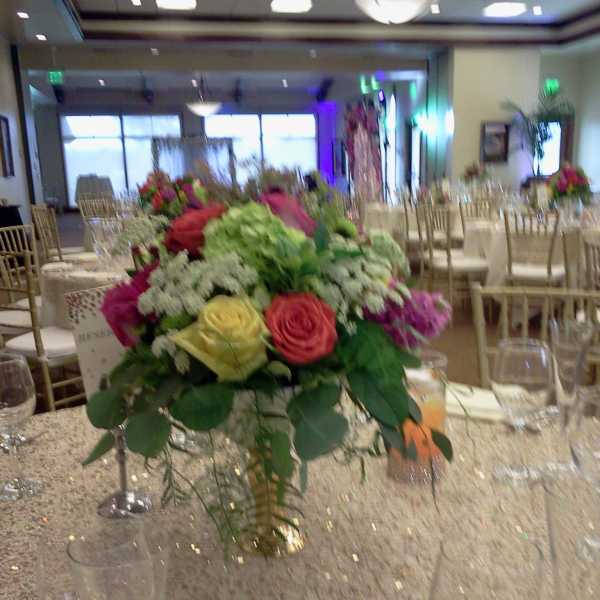 Round centerpiece of multicolored roses on a banquet table