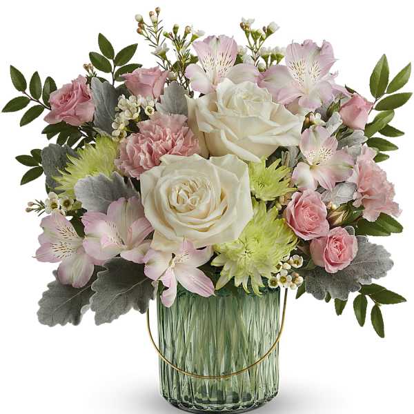 Pink and white flowers arranged in a green glass vase
