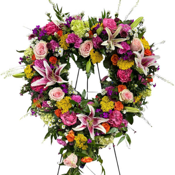 Large floral wreath on an easel with pink, orange, yellow, and white blooms