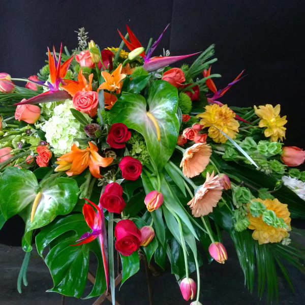 Large tropical floral arrangement with roses, lilies, and bird-of-paradise