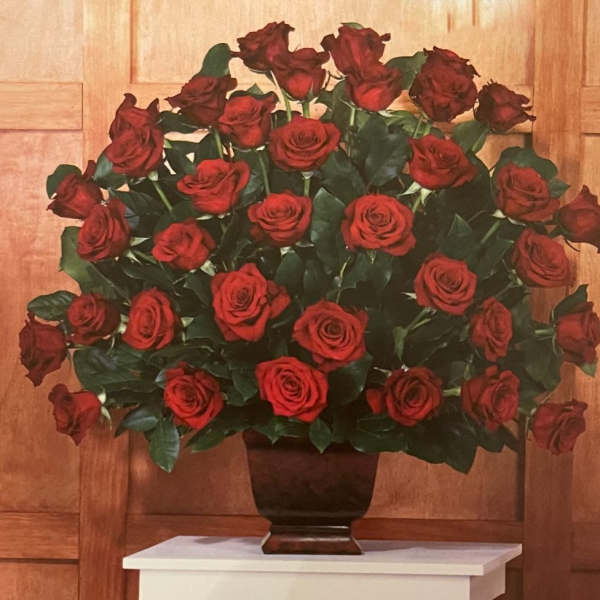 Large arrangement of red roses in a dark vase