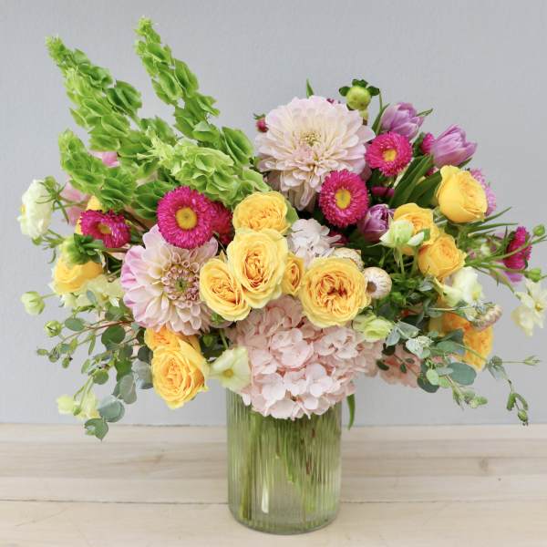 Mixed bouquet of yellow and pink flowers in a glass vase