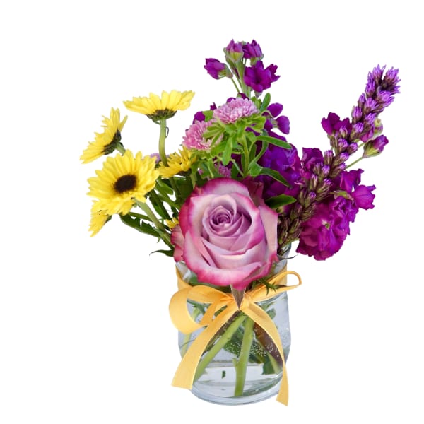 Mixed bouquet of purple and yellow flowers in a glass vase with a yellow ribbon