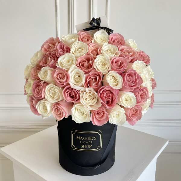 Bouquet of pink and white roses in a black hat box