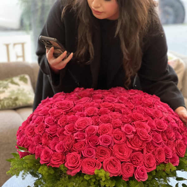 Large dome of hot pink roses in a low white container