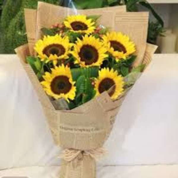 Bouquet of yellow sunflowers wrapped in brown paper