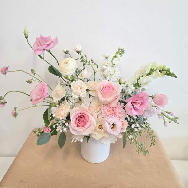 Pink and white floral arrangement in a white vase