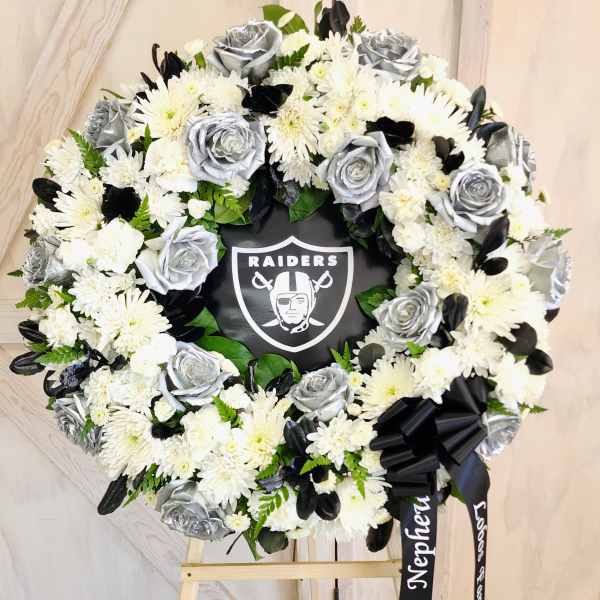 Black and white floral wreath with a Raiders logo in the center