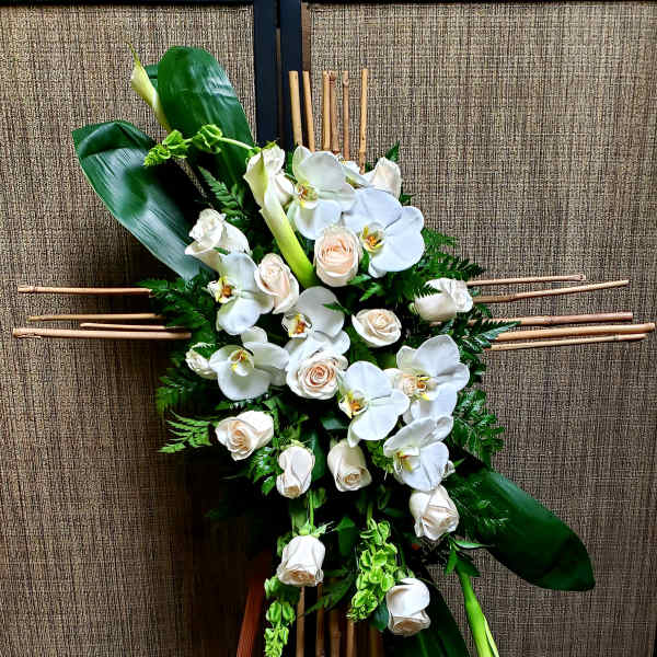 White orchids and roses arranged on a bamboo stand