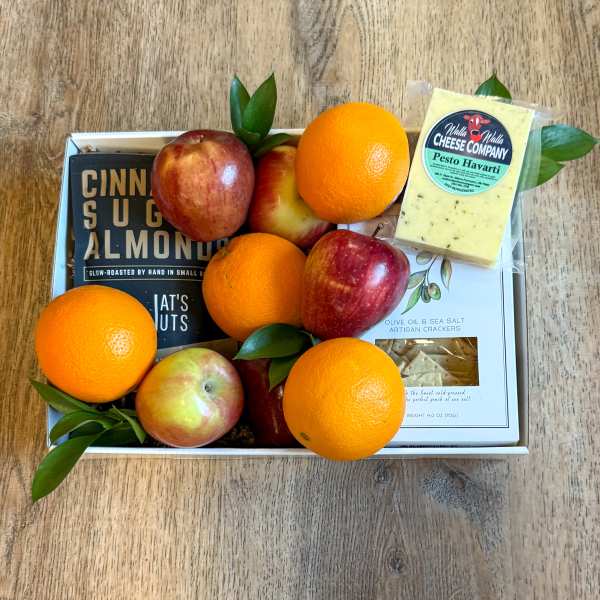 Gift box with oranges, apples, and packaged cheese and crackers