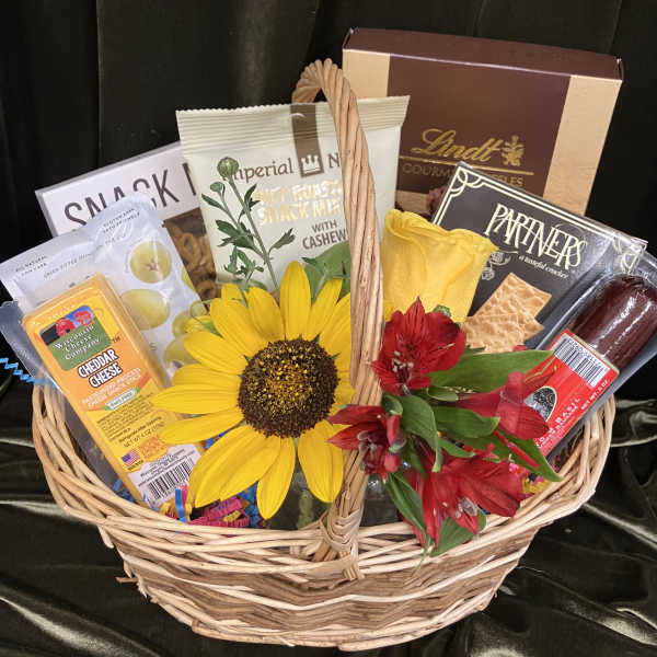Gift basket with snacks, chocolates, and yellow and red flowers