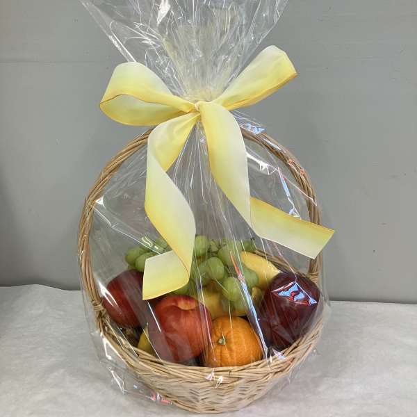 Fruit basket wrapped in clear cellophane with a yellow ribbon
