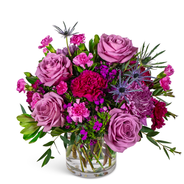 Lavender roses and pink mixed flowers in a clear glass vase
