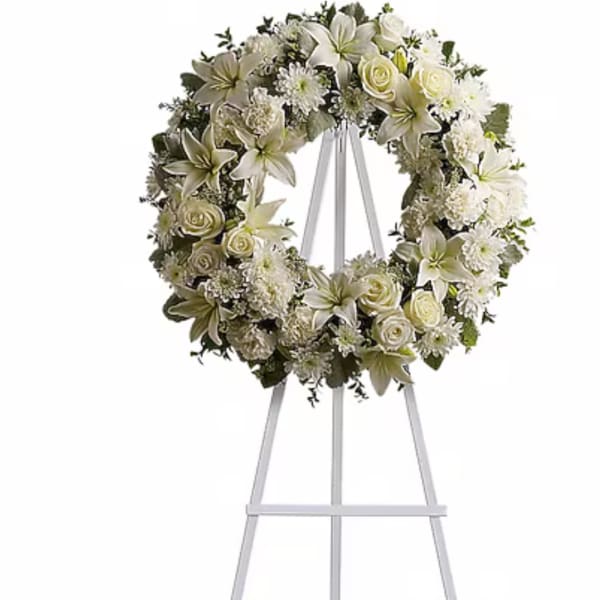 White floral wreath on a tall metal easel